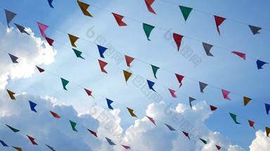色彩斑斓的设计装饰三角公平旗帜吹风挂蓝色的天空背景有趣的节日聚会，派对事件盛宴庆祝活动假期狂欢节节日事件